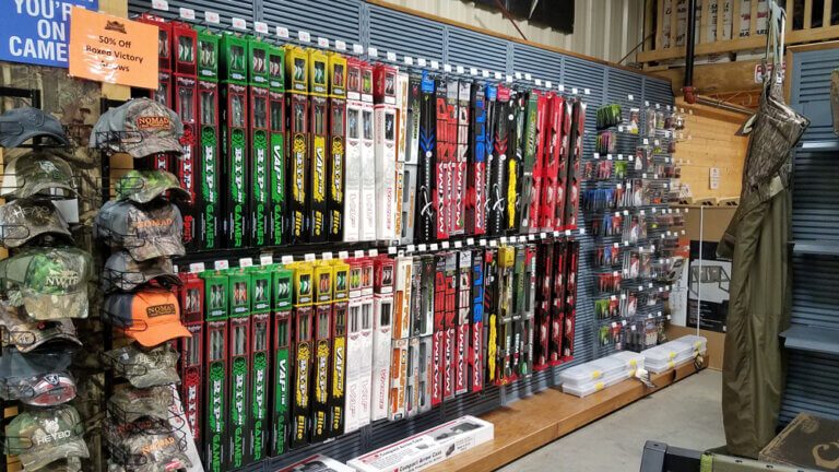 A store display of archery arrows, hats, and gear