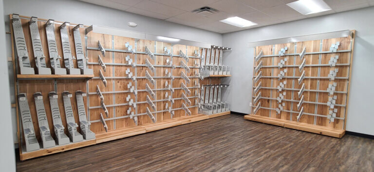 A room with a wooden wall and a modular unit displaying shelves.