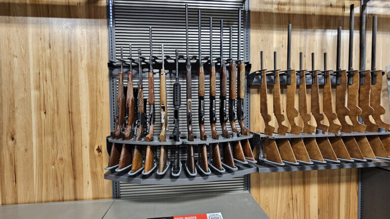A display rack featuring various firearms in a retail store setting