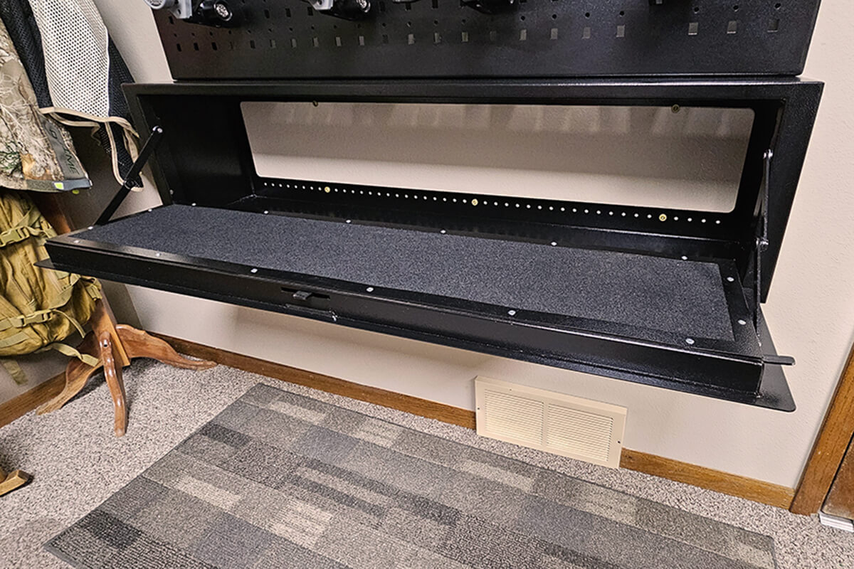 A wall-mounted gun safe featuring a secure gun rack for organized firearm storage and protection.